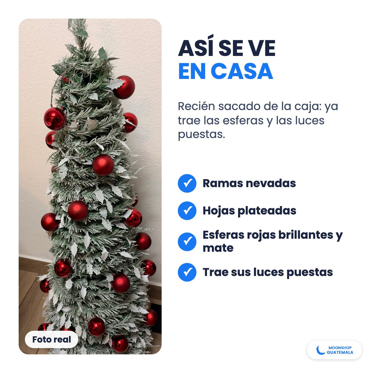 Foto real del árbol de Navidad nevado con esferas rojas y hojas plateadas