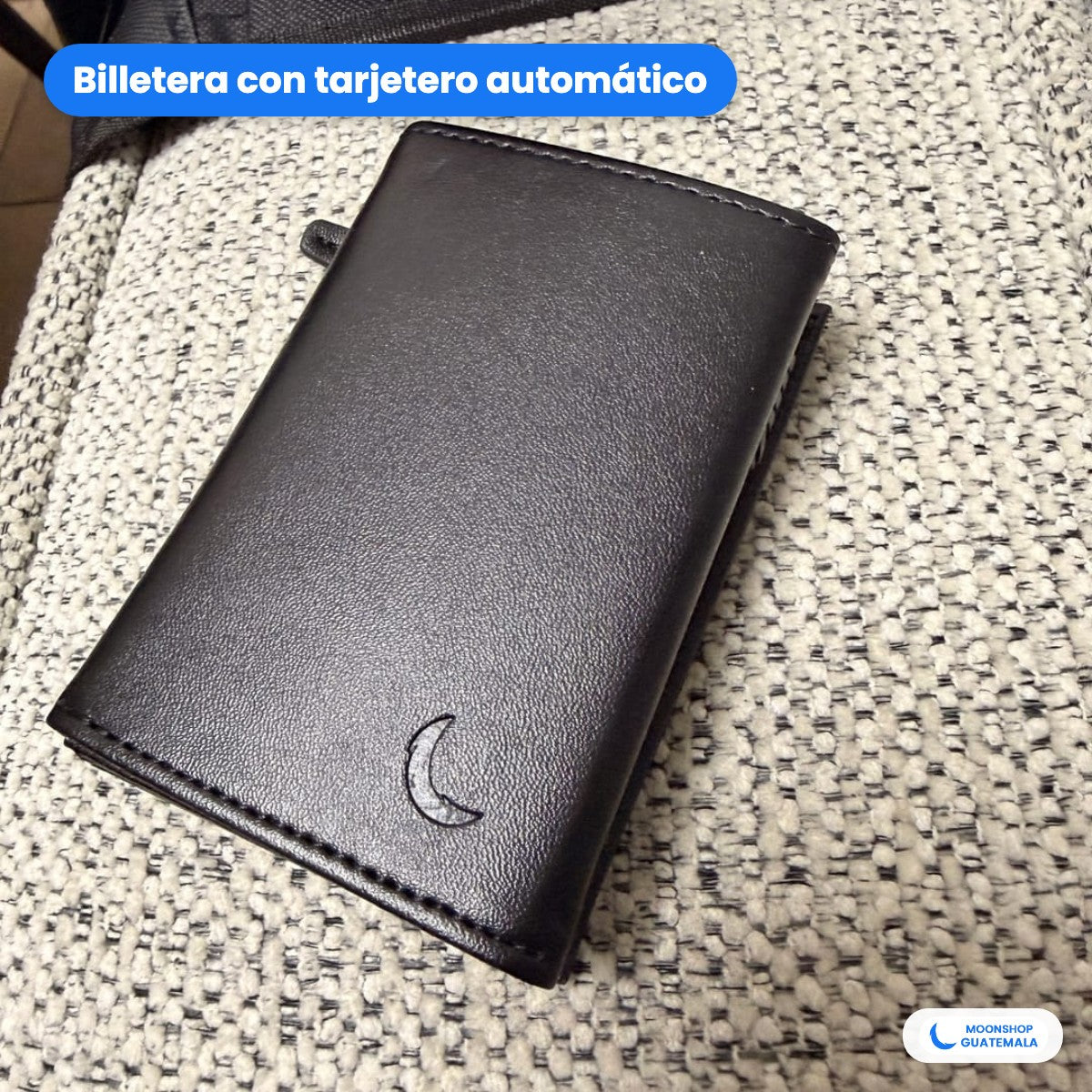 Billetera negra de cuero PU cerrada, con la lunita de Moon Shop en relieve al frente y la palanca del tarjetero en el lomo