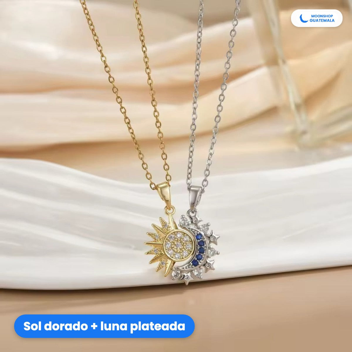 Collar ECLIPSE: el collar del sol dorado y el de la luna plateada juntos, colgando sobre una tela blanca