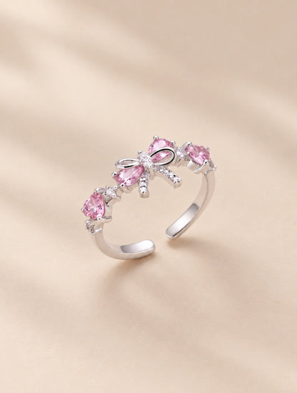 Anillo plateado con lazo y cristales rosados de banda abierta