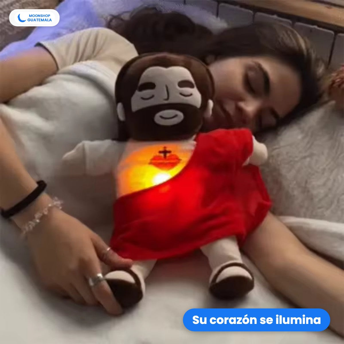 Peluche de Jesús que respira rojo, encendido, con el corazón iluminado mientras una mujer lo abraza