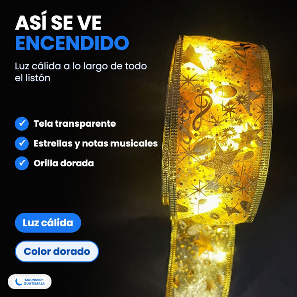 Listón con luces LED dorado encendido visto de cerca: tela transparente con estrellas y notas musicales y luz cálida