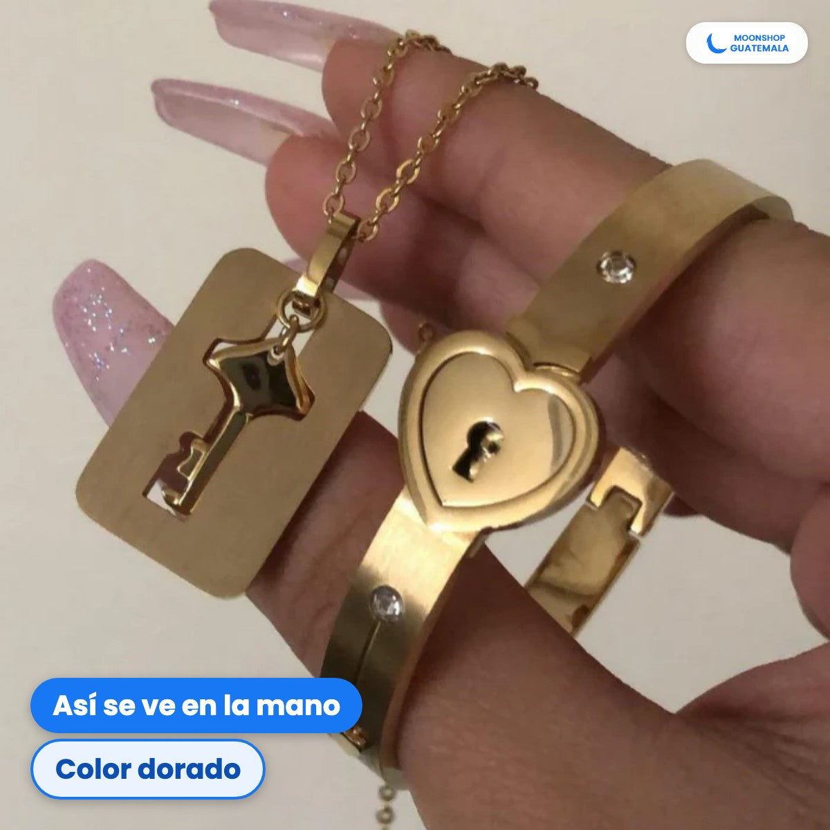 Pulsera con candado de corazón y collar con la llave en color dorado, sostenidos en la mano
